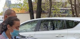 Femeie care se dădea drept asistentă medicală, trimisă la puşcărie de judecătorii ieşeni! Totul, în urma unor „ţepe”! FOTO (EXCLUSIV) O femeie cu masca de protectie la gura si la nas, condusa de un barbt in spatele sediului Judecatoriei Iasi