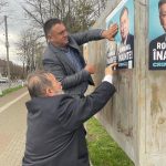 Neculai Zugravu și Dumitru Pintilie, lipesc afișe